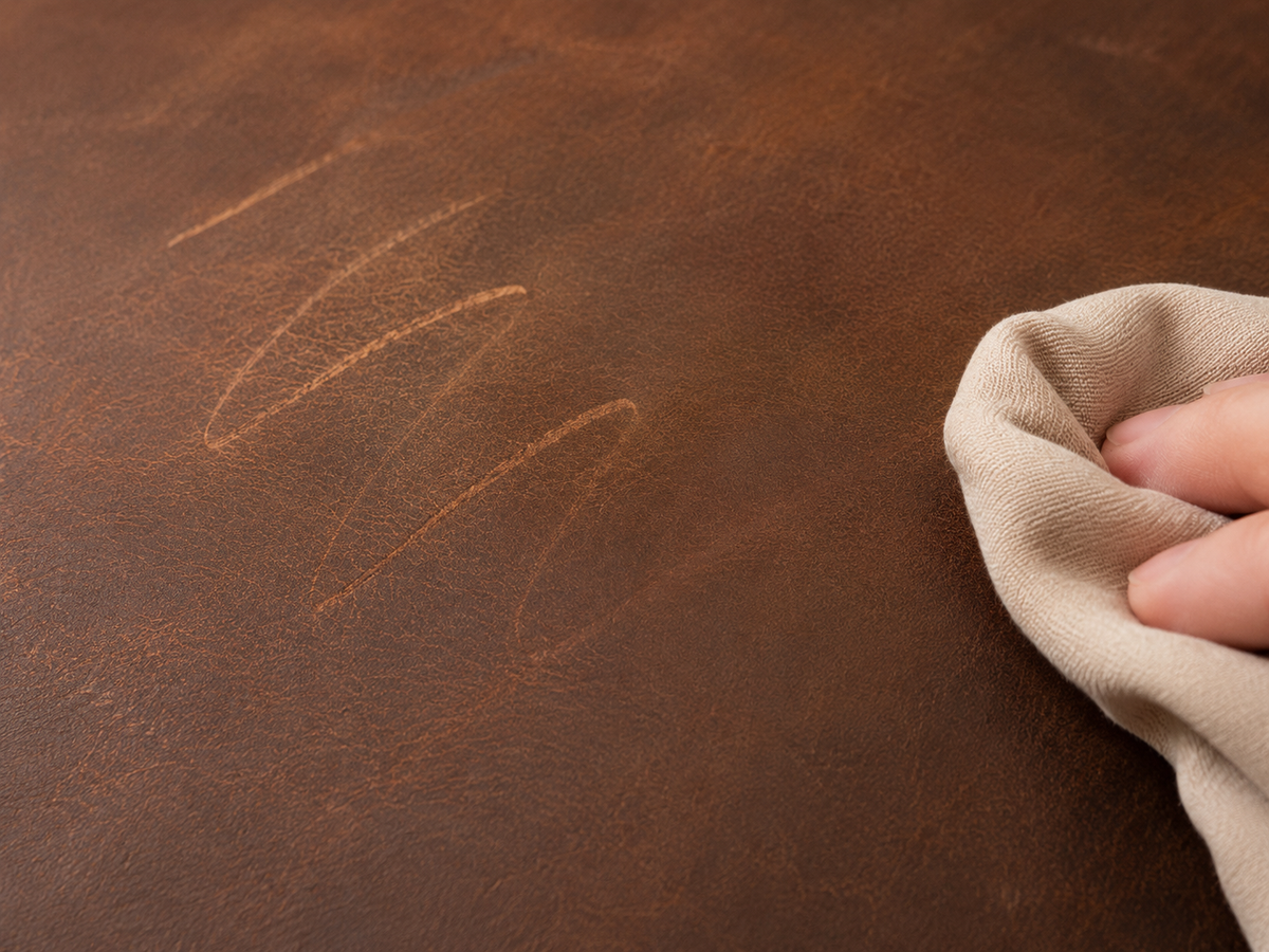 Surface marks on Crazy Horse leather being gently buffed with a soft cloth to restore an even appearance