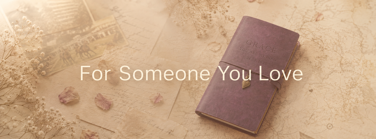 Personalised purple leather journal engraved with a meaningful message and date beside dried flowers and a vintage map